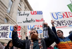 file photo people hold placards outside the usaid building after billionaire elon musk who is heading u s president donald t