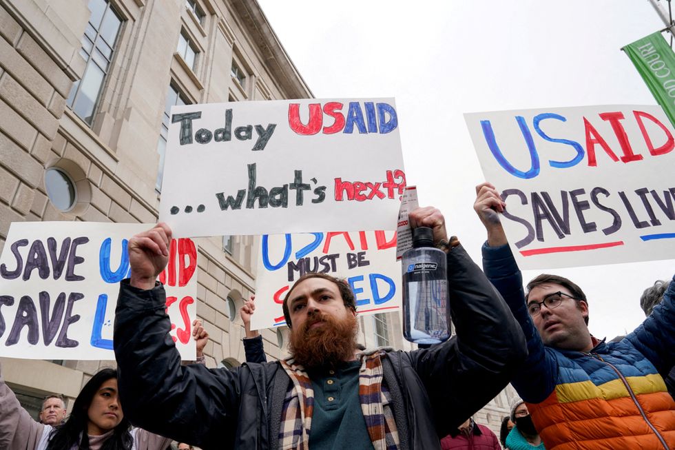 file photo people hold placards outside the usaid building after billionaire elon musk who is heading u s president donald t